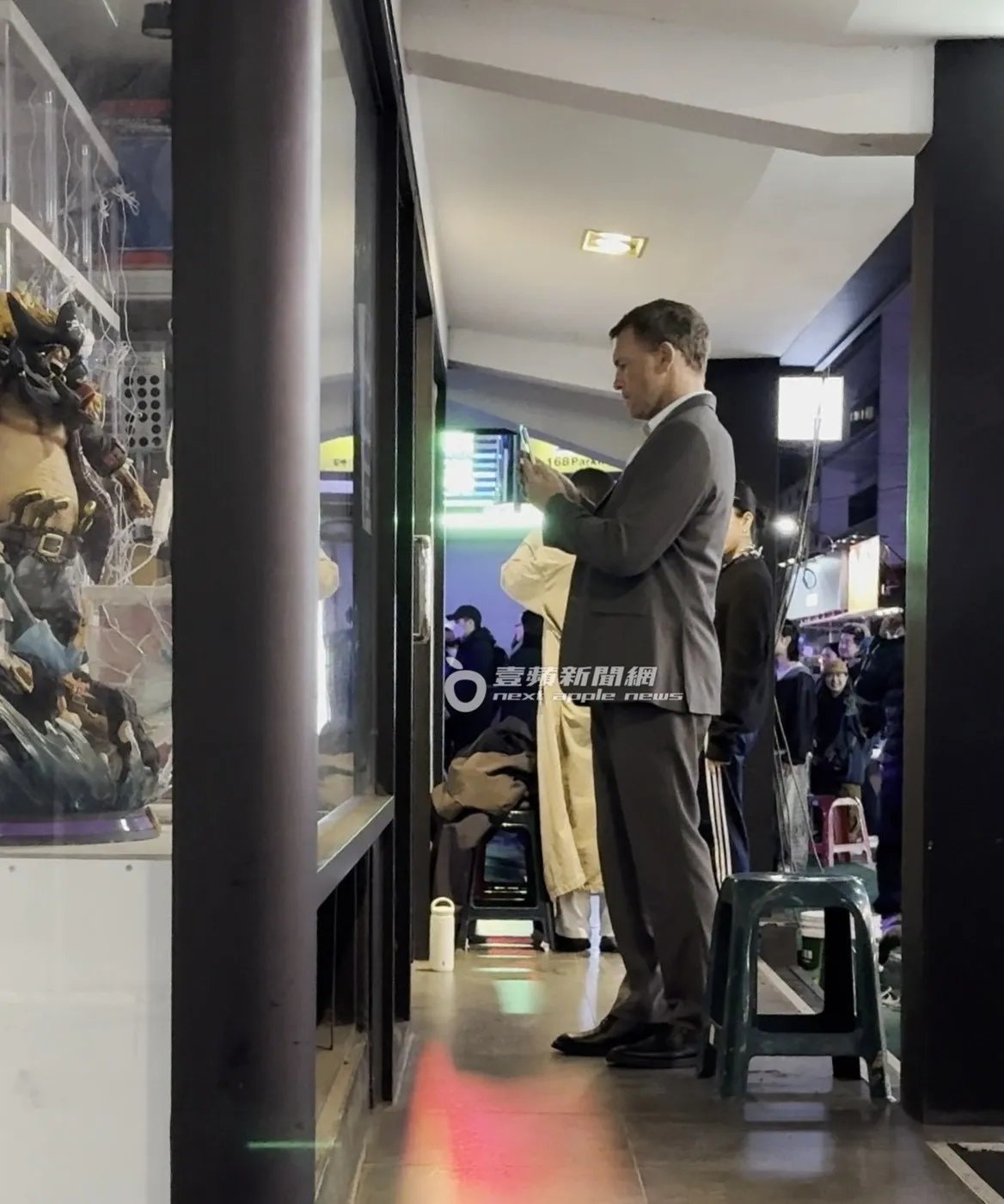 山姆沃辛頓跟助理拿了自己的手機，準備拍攝店家櫥窗內的大型公仔。特勤中心攝