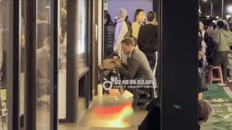 山姆沃辛頓好奇蹲下拍攝櫥窗內的大型公仔。特勤中心攝