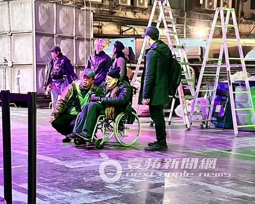 知名攝影師愛德華拉赫曼坐在輪椅上指導工作人員。特勤中心攝