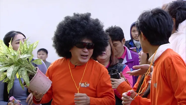 胡瓜（左）戴黑人頭，獻上盆栽當花束。民視提供