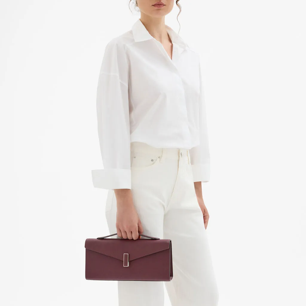 Iside家族系列以標誌性金屬鎖扣與建築感線條搭配莧紫紅色調呈現當代而優雅的節慶風格。品牌提供