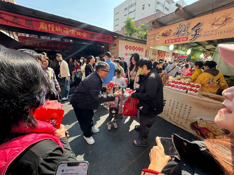 命理大師詹惟中在全台最靈驗的台北霞海城隍廟前廣場，發放限量紅包。民眾提供