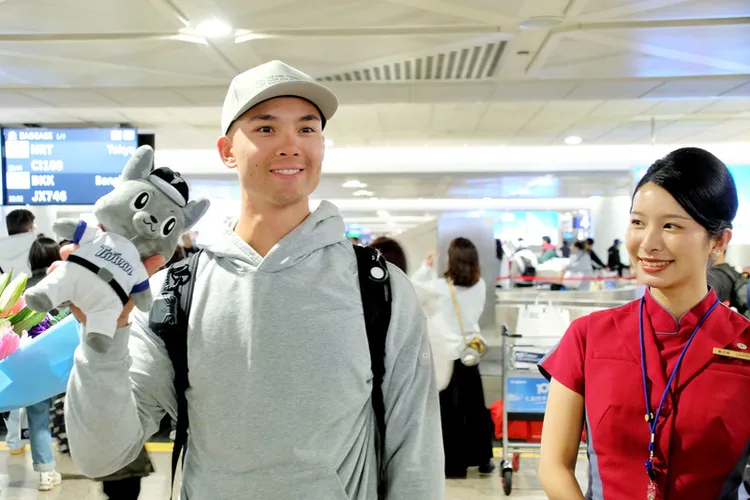 台美混血好手「費仔」費柴德26日晚間搭機抵台，在機場開心收下中職吉祥物「歐告」娃娃。中央社