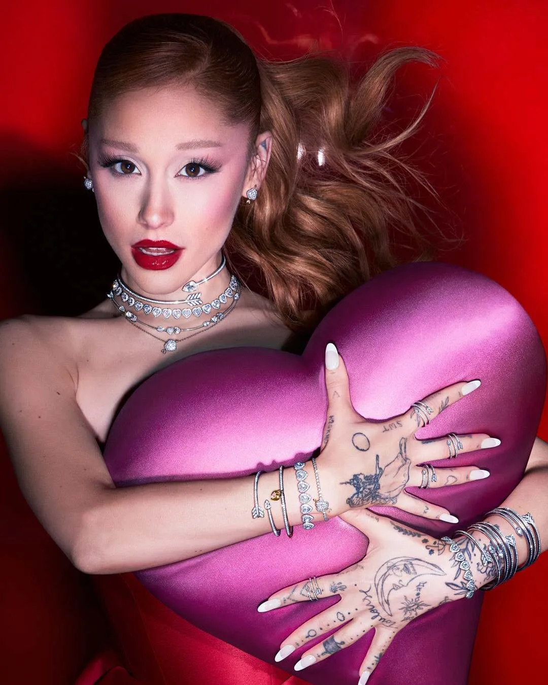 亞莉安娜以火紅唇妝搭配綴滿愛心與鑰匙圖騰的華麗珠寶。品牌提供