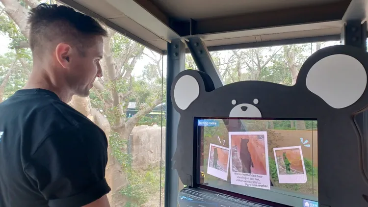 外國遊客於黑熊廊道體驗「AI智慧環境導覽系統」。翻攝畫面