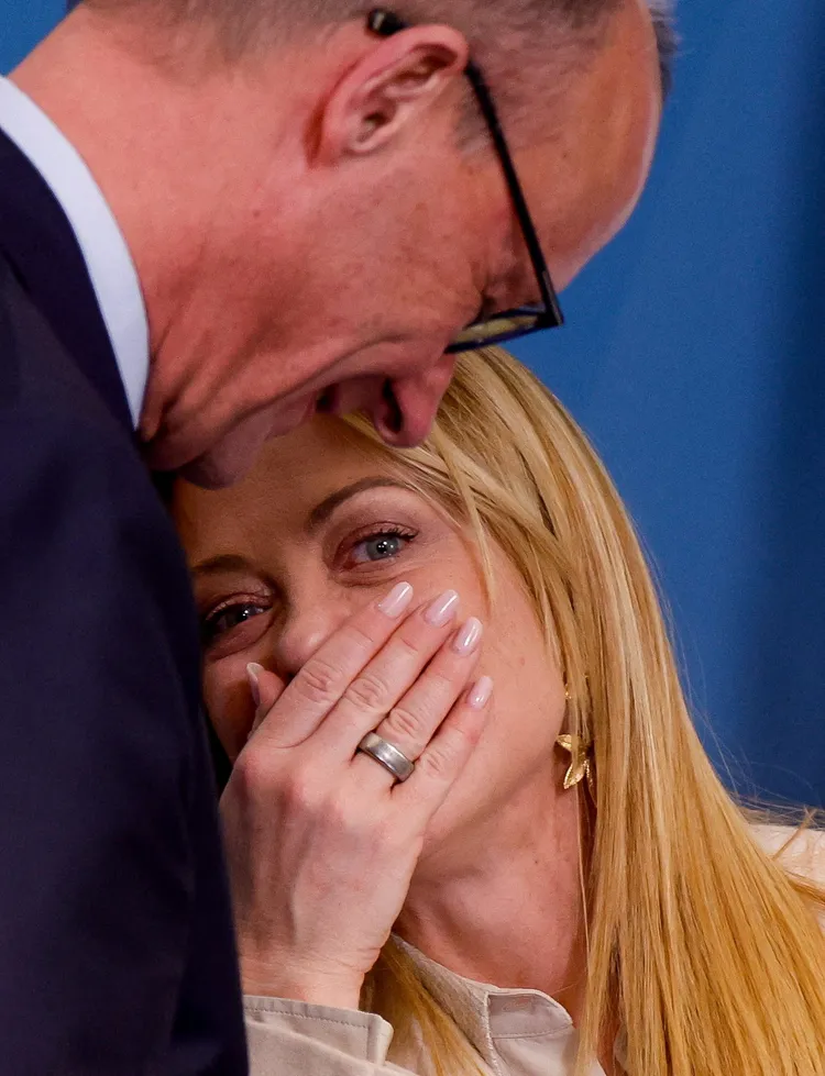 49歲的梅洛尼（右）風韻猶存，圖為她與德國總理梅爾茨說悄悄話。路透社