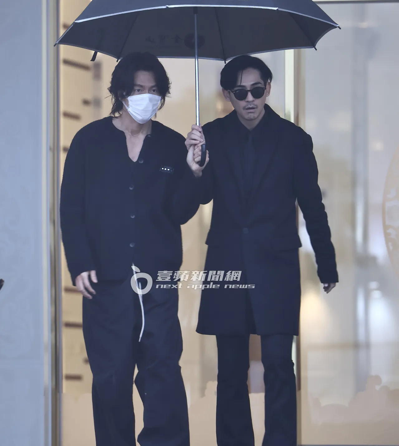 大S前男友周渝民（右）與言承旭共撐一把傘離開。特勤中心攝