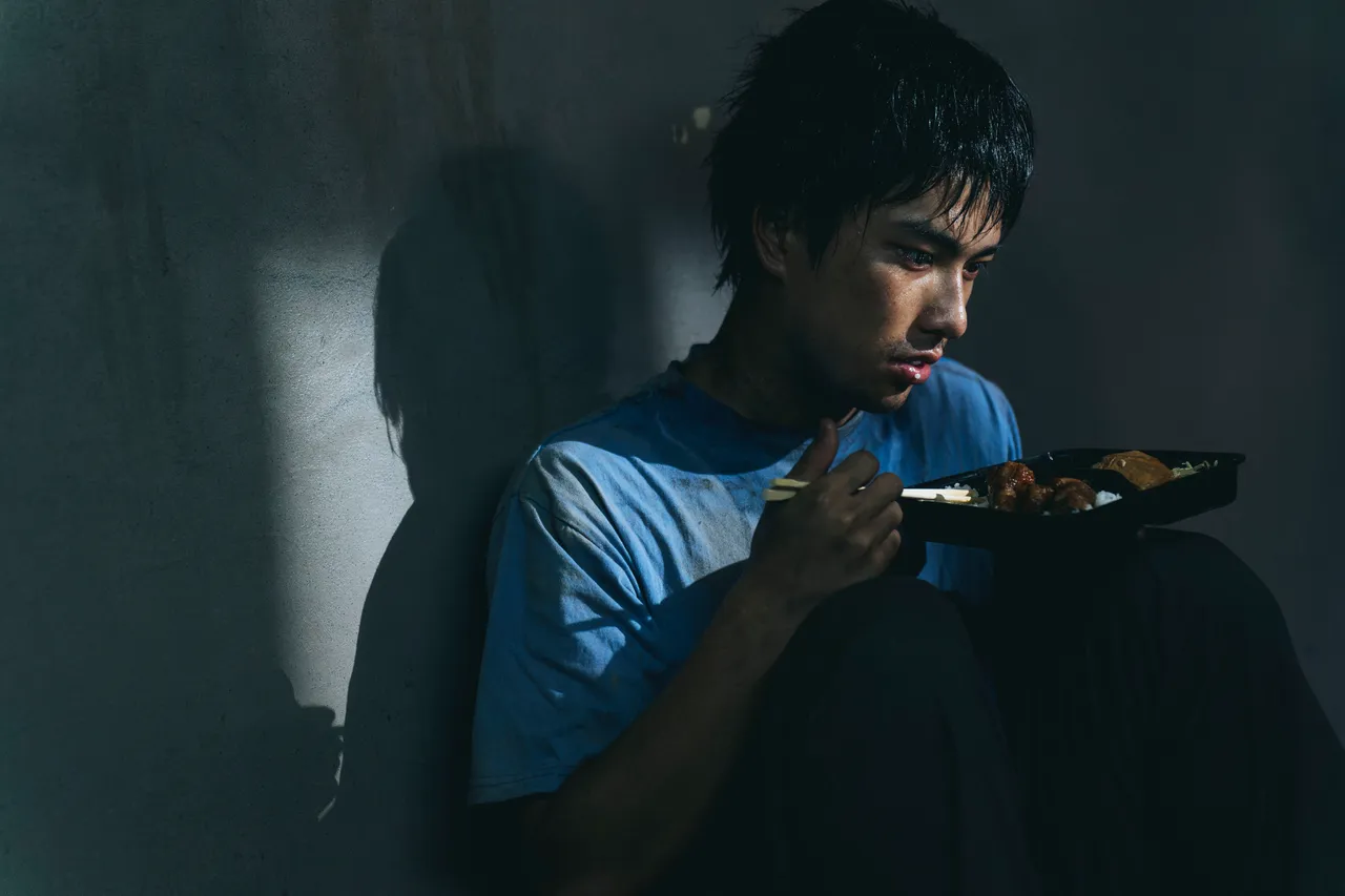 曾敬驊滿身污漬蜷縮紙板。冬候鳥電影、文策院提供