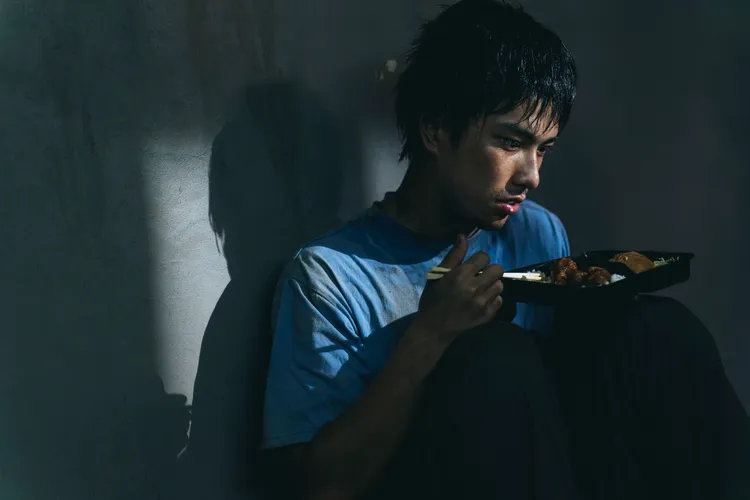 曾敬驊滿身污漬蜷縮紙板。冬候鳥電影、文策院提供