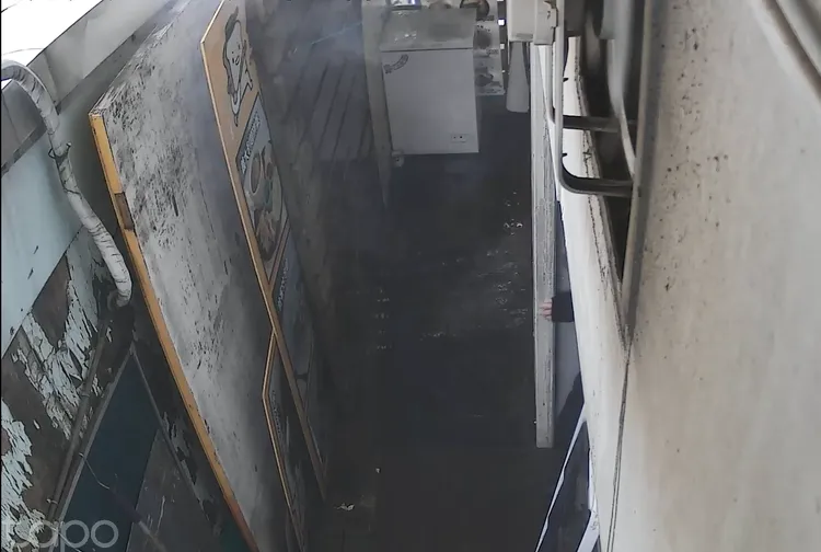 建築物縫隙處角落處常積易燃可燃物，遭抽菸者亂丟菸蒂引起火災。翻攝畫面