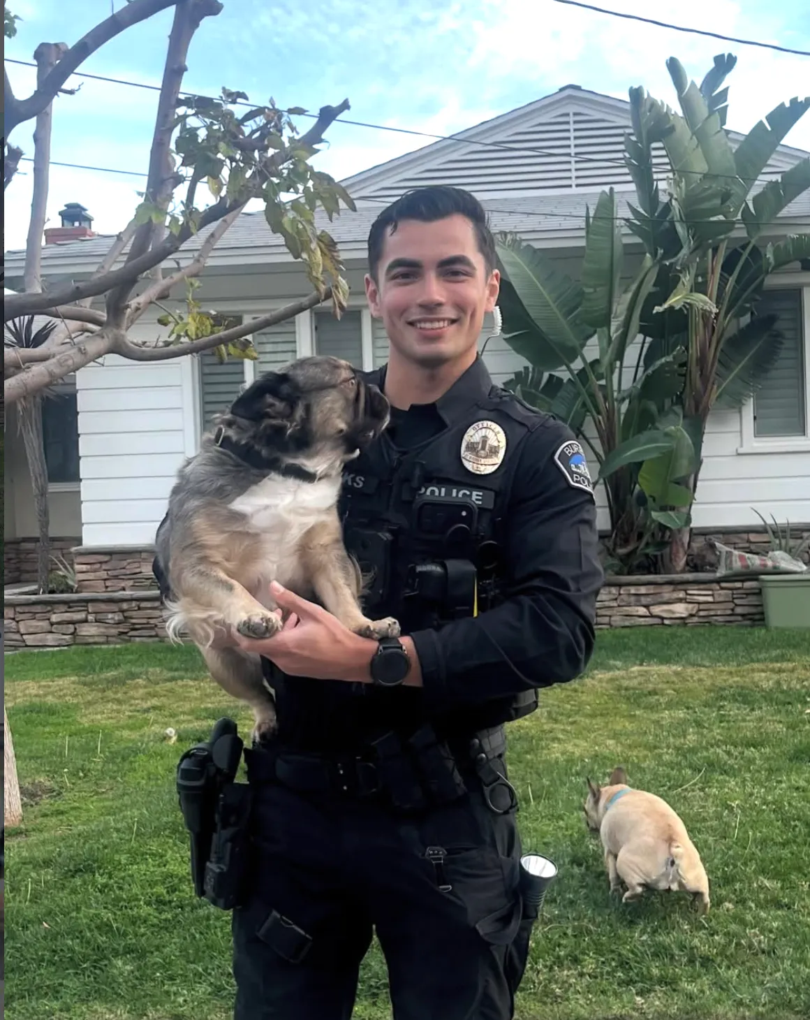 陽光帥氣的帕克斯警官懷中抱著的法鬥犬盯著他看，另一隻法鬥犬則傷心轉頭離去。翻攝IG@Burbankpolcedepartment