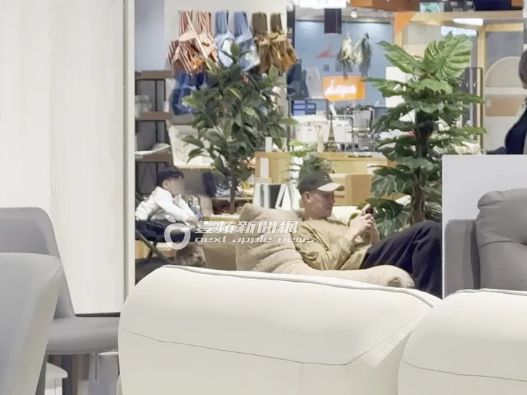 林書豪坐在沙發上滑手機，不到30秒便起身陪伴坐在嬰兒車上的兒子。特勤中心攝