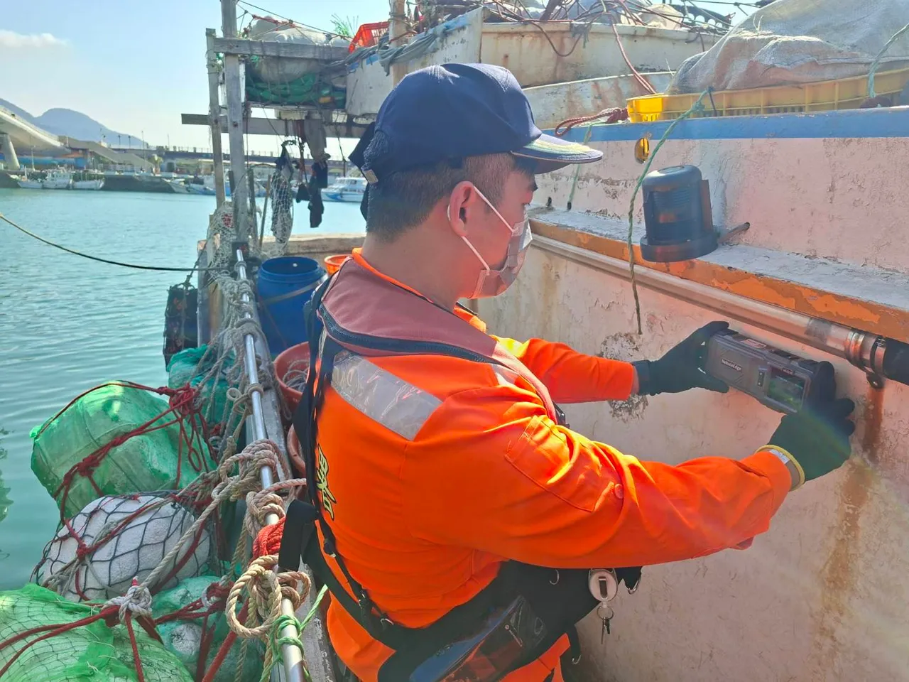 海巡人員使用手持式穿牆雷達生命探測器檢查漁船。翻攝畫面