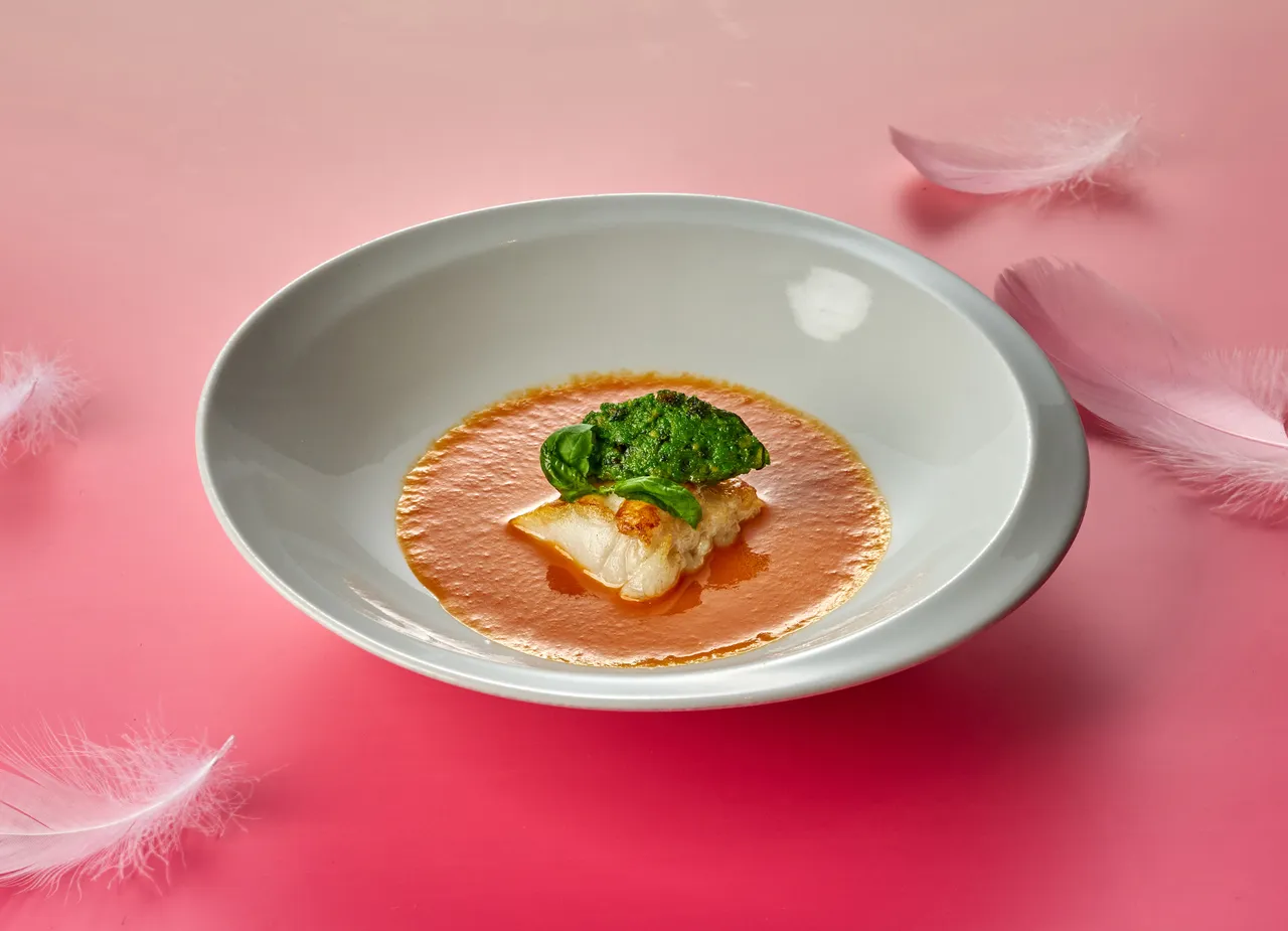 湯品嚴選大西洋鱈魚經低溫舒肥後，將表皮煎至金黃酥脆，佐以羅勒青醬，緩緩注入費時熬煮的番茄濃湯，天然酸甜果香巧妙平衡魚肉油脂，滋味溫潤。台北美福大飯店提供