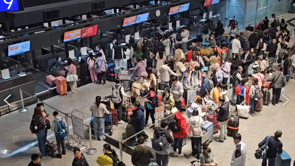 春節9天連假首日，桃園國際機場14日湧現大批要出國的旅客，辦理登機的隊伍長得看不到尾巴。中央社