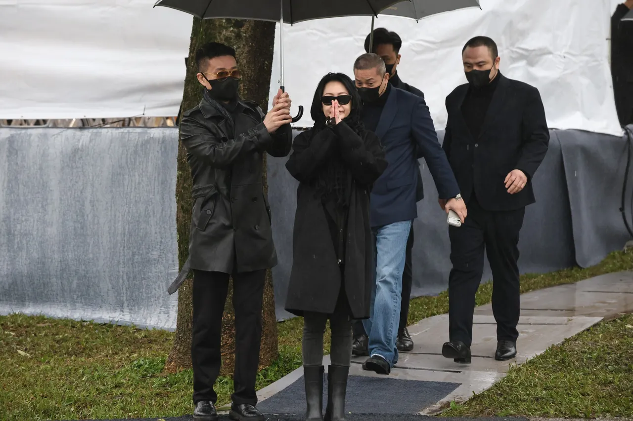 大S紀念雕像揭幕儀式結束，小S（中）在老公許雅鈞陪伴下，雙手合十，向媒體鞠躬致意。特勤中心攝