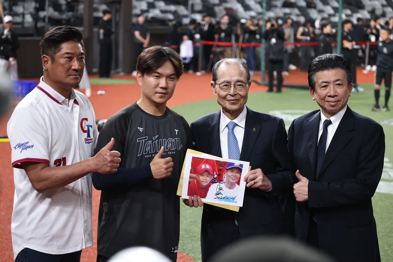 江坤宇出示和王貞治的合照。  彭欣偉攝