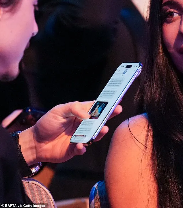 他開心看朋友傳給他的迷因圖。