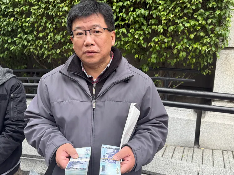 他早上7點40分就來排隊，自己每年農曆年前都會固定來換新鈔，上週已先兌換20萬元，今天再補齊各面額鈔券，準備幫同事與家人換鈔。呂承哲攝
