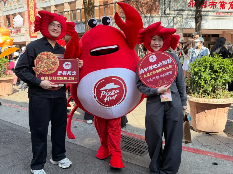 今日必勝客在台北年貨大街現場，限量發送春節新品「金皇軟殼蟹鮑魚披薩」免費試吃。莊偉祺攝