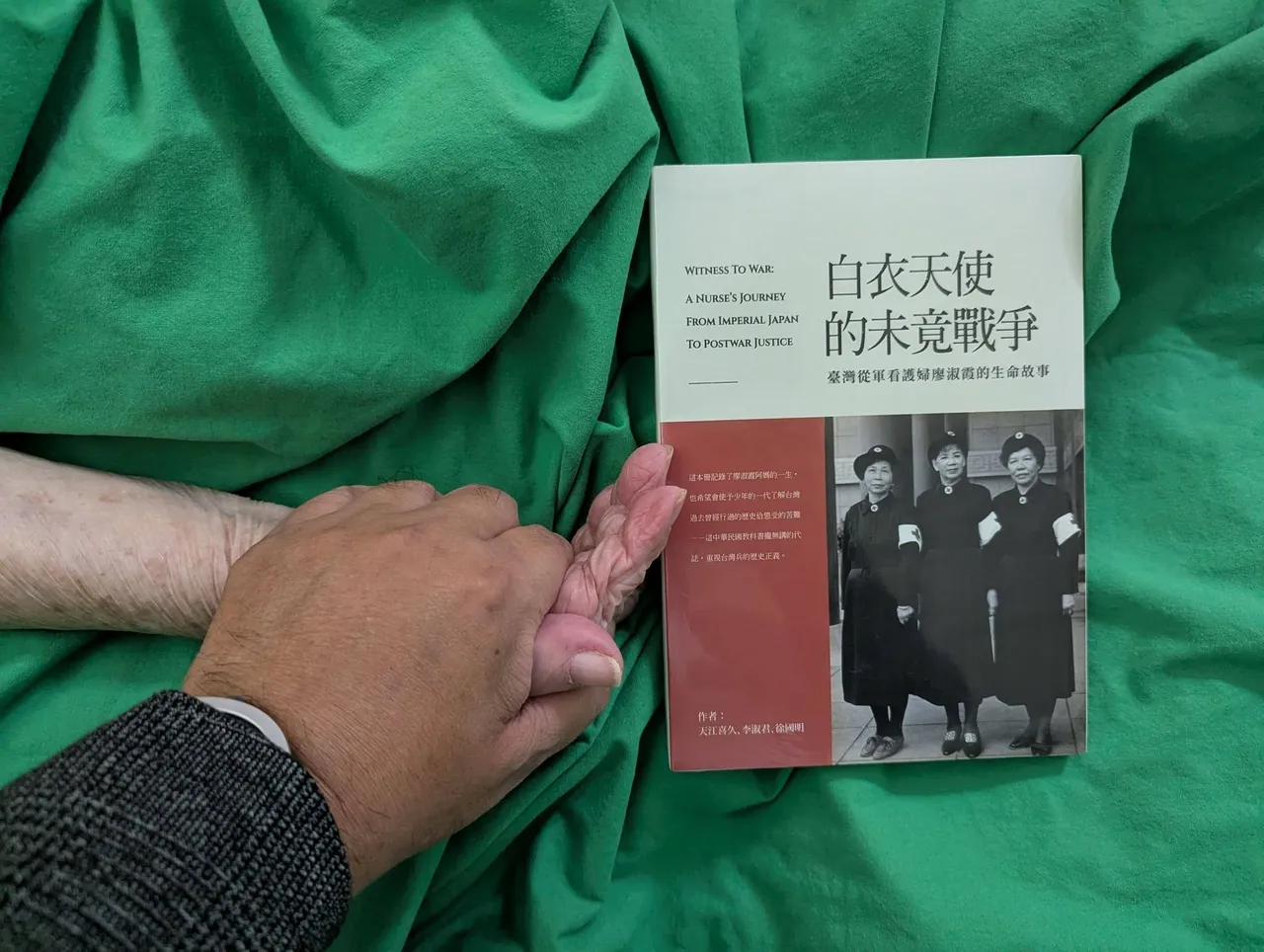 朱家煌拿著剛出版的傳記《白衣天使的未竟戰爭》，給阿媽打氣。朱家煌提供