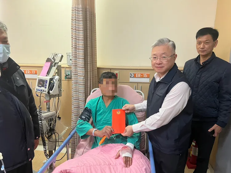 苗栗縣警局長李忠萍探視見義勇為遭子彈誤傷手掌的羅姓民眾。民眾提供