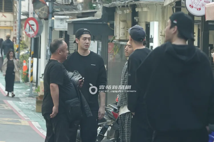 寶弟與鹿希派一行人在路邊圍成一圈，一邊抽加熱菸聊天。特勤中心攝