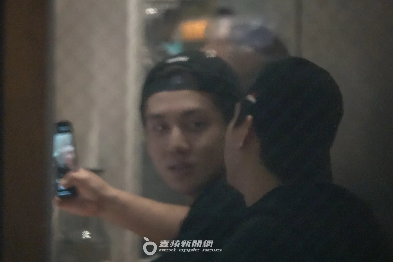 寶弟（左）開心拿手機和友人自拍，看上去心情甚好。特勤中心攝