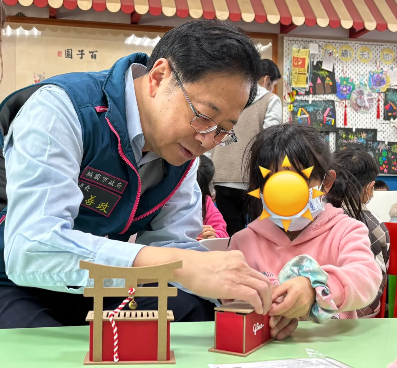 張善政與安置中的兒童互動。社會局提供