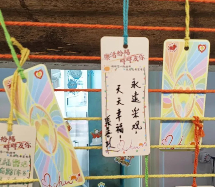 張善政寫下永遠樂觀 天天幸福祝福安置中的兒少。社會局提供