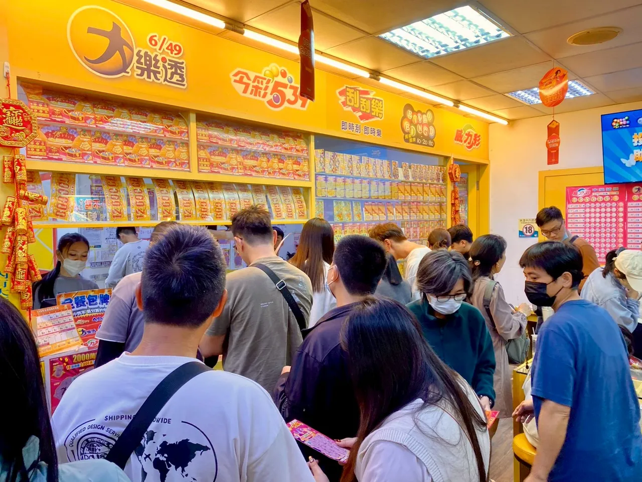 春節期間大樂透加碼，彩券行擠滿人潮，民眾搶買拚好運。攝影中心
