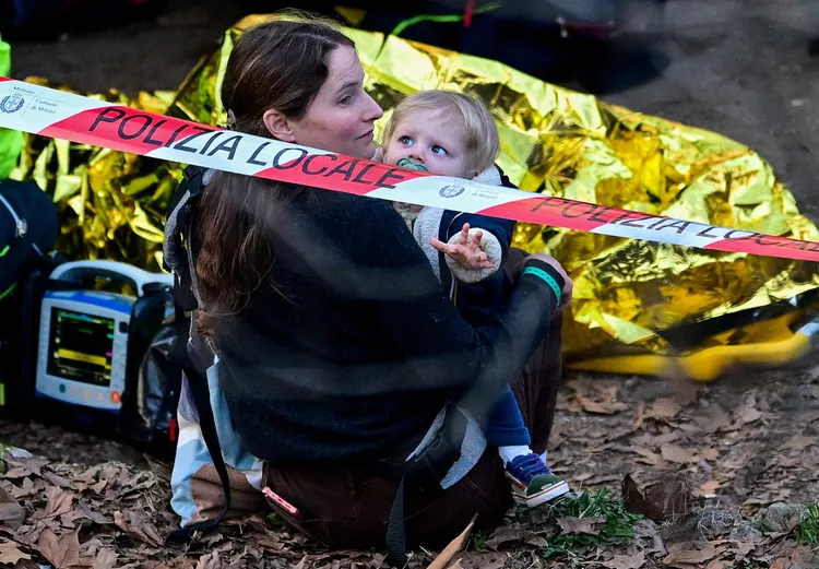 抱著小孩的女子似乎未受傷。路透