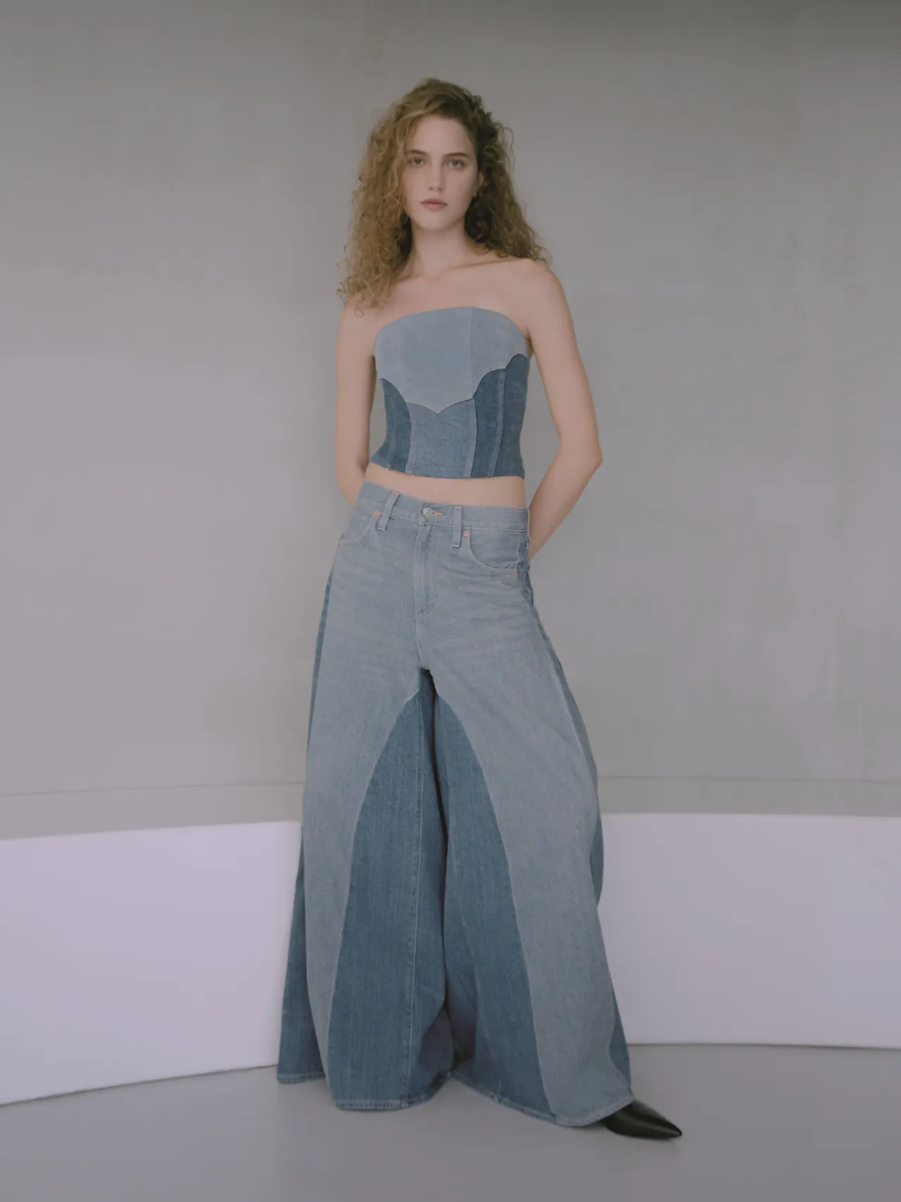 女裝運用水洗工藝與異材質拼接，讓寬版丹寧褲呈現如「彩色鑲嵌玻璃」般的湛藍層次。品牌提供