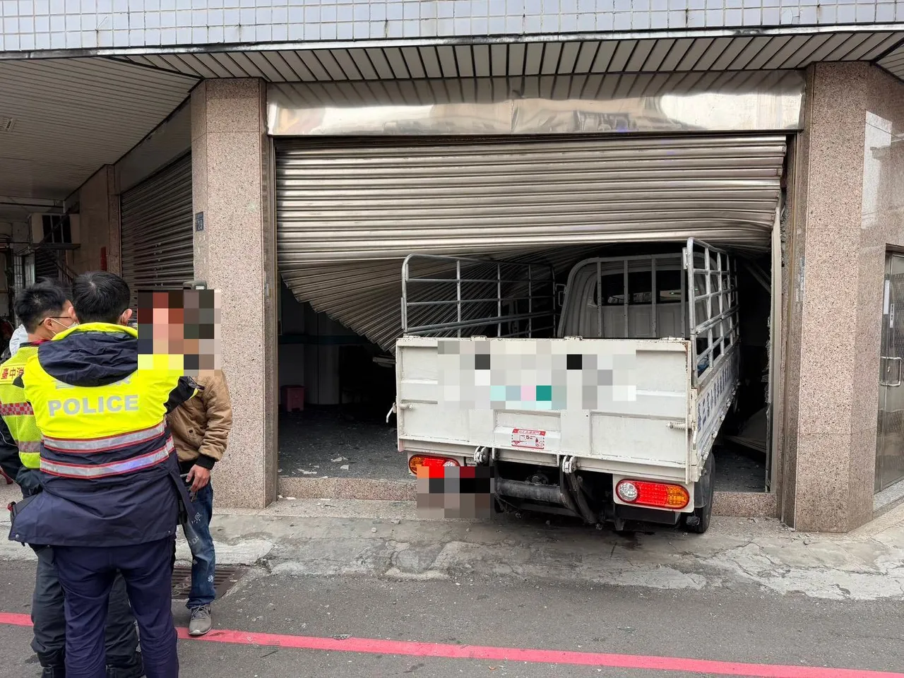 民宅鐵捲門被小貨車撞到掀開。民眾提供