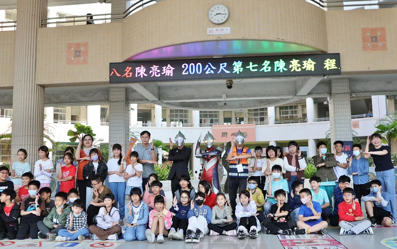 新上國小校長王彥嵓與老師們化身「超人力霸王」，站在校門前熱情迎接返校的孩子。翻攝畫面