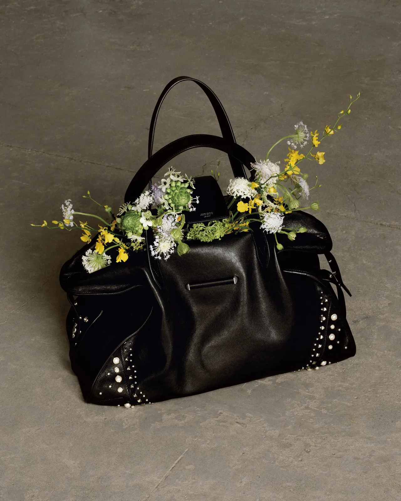 黑色皮革BAR HOLDALL包點綴鉚釘元素，釋放中性酷颯魅力。品牌提供