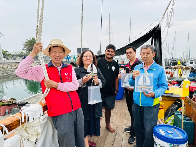 前鎮國小與大潭國小校長等到場歡迎，致贈師生們親手製作的「無私分享號」帆船雷雕。翻攝畫面