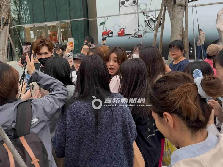 陳意涵（中）在工作人員護送下步出影城，上百位熱情粉絲緊跟在後。特勤中心攝