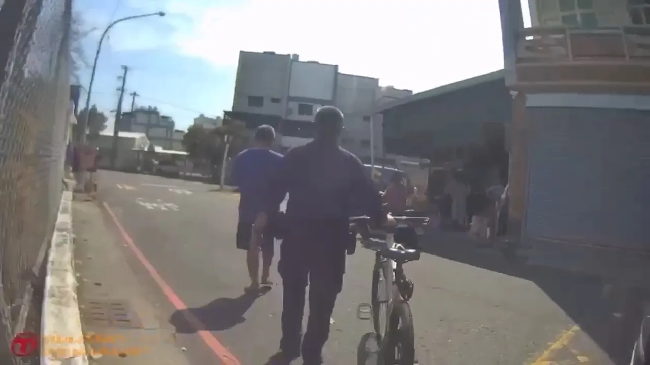 劉副所長牽著腳踏車，一路步行護送呂男返回住處。翻攝畫面