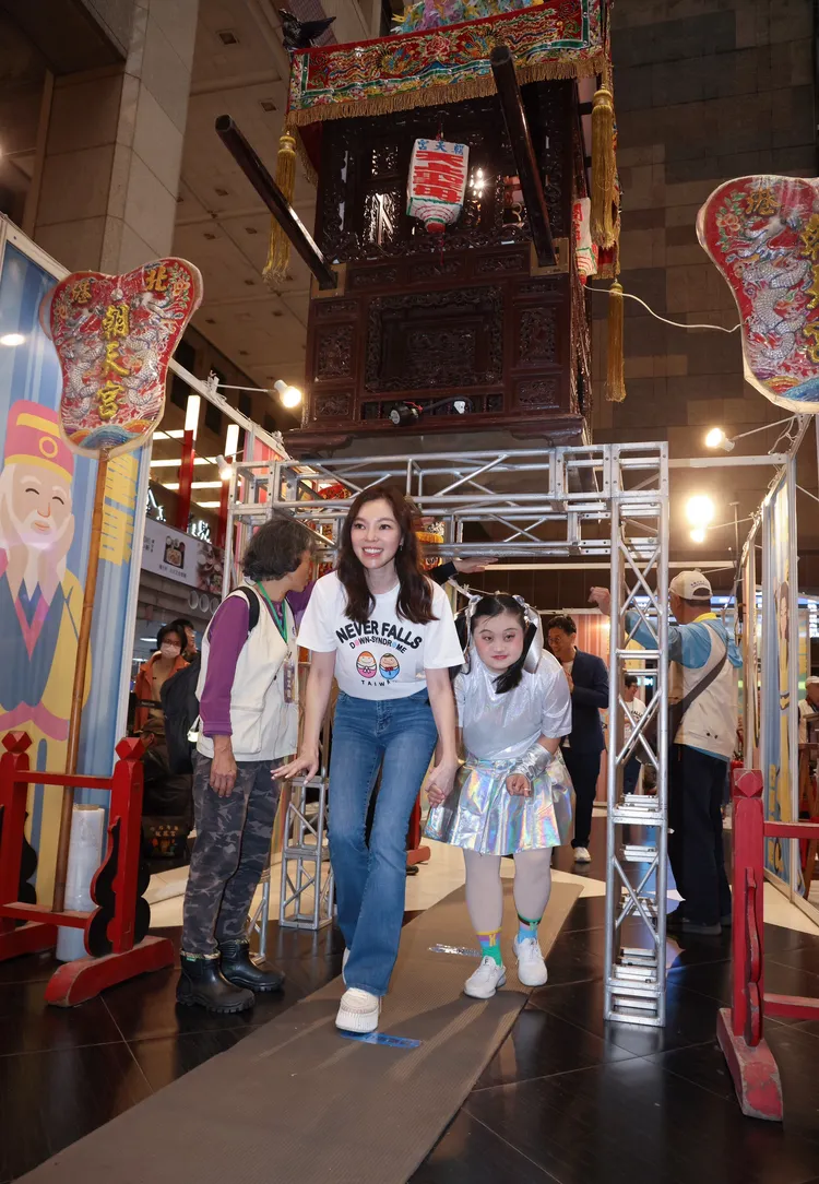 曾馨瑩牽著唐寶寶「鑽轎底」。彭欣偉攝
