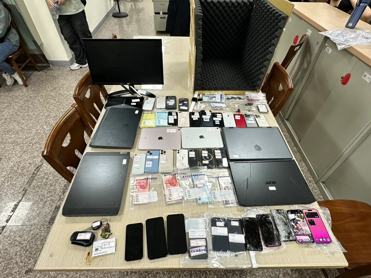 警方查扣手機32支、平板2台、筆電4台、14萬3,200元、自小客車2輛、工作隔音箱等證物。翻攝畫面