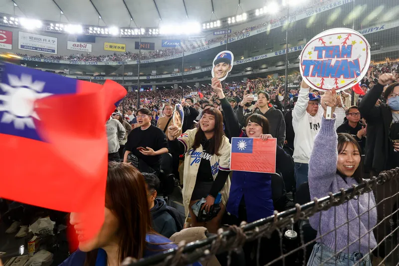 球迷高舉國旗加油。中央社