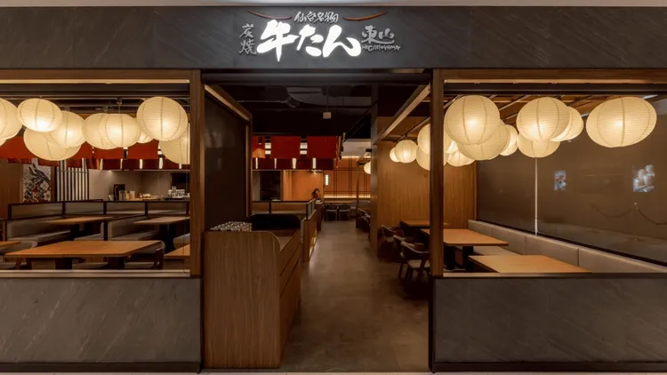 「東山牛舌」打造日式沉靜用餐氛圍，暖黃和紙燈籠映木質空間。業者提供