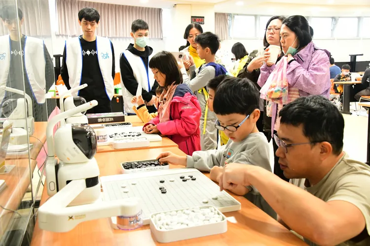 選手們體驗與下棋機器人對弈。校方提供
