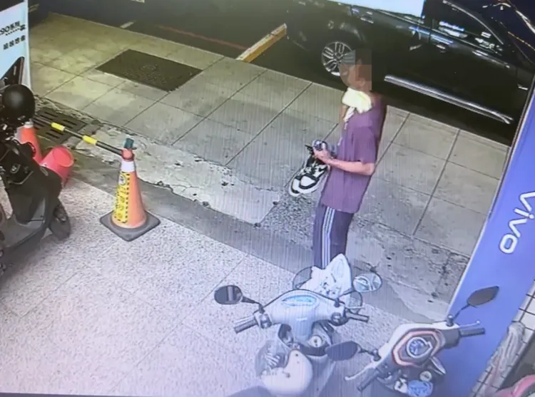 男子站在機車前左顧右盼，伺機而動。林姓民眾提供