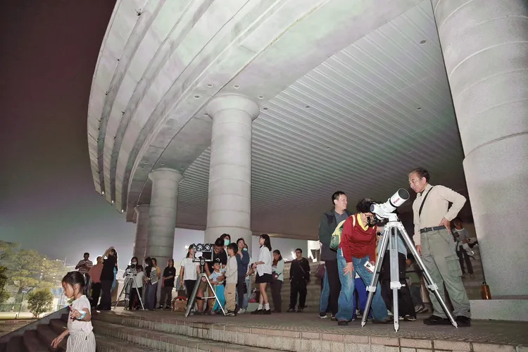 民眾透過望遠鏡觀測月全食。翻攝畫面