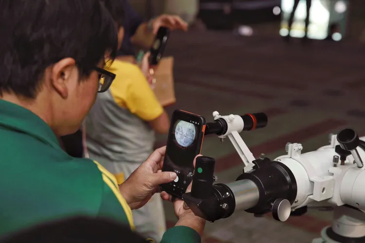 民眾透過專業天文設備拍攝月全食照片。翻攝畫面
