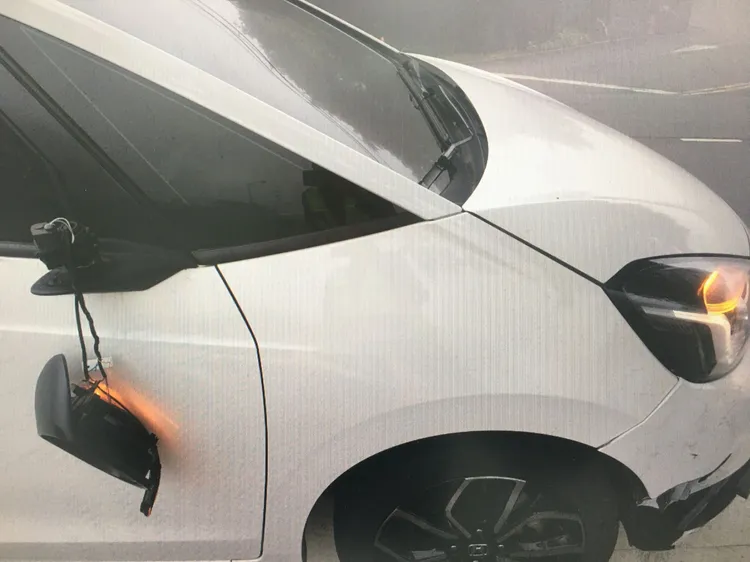 肇事的白色小客車車頭、後照鏡受損，男駕駛稱有蜘蛛爬上臉才會衝到逆向。翻攝畫面