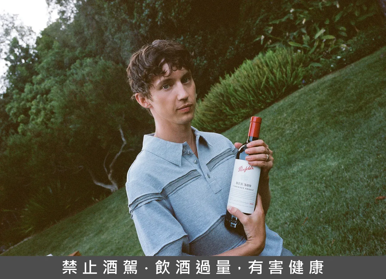Troye Sivan 與聯名款 Bin 389 紅酒合影，這款收藏級佳釀將於 3 月起在精品與旅遊零售通路限量發售。奔富提供