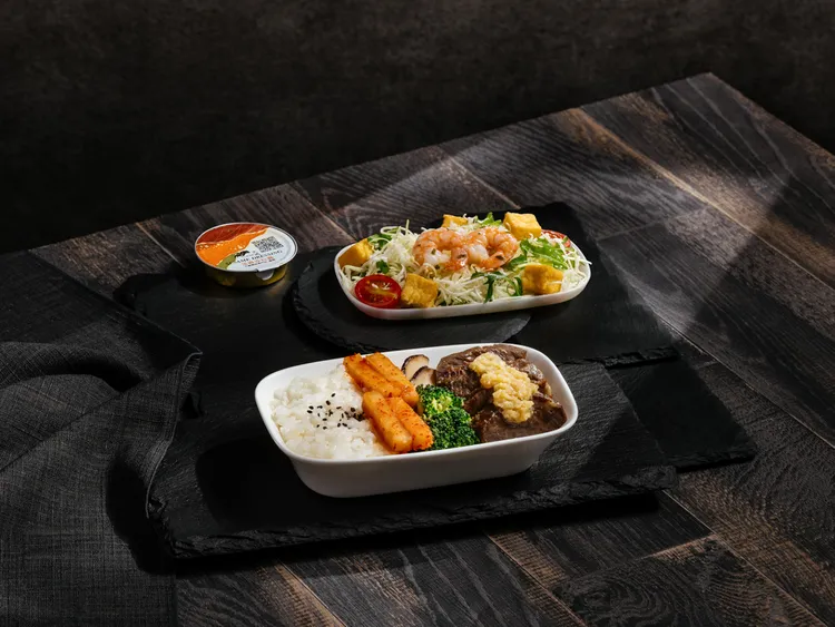 豪華經濟艙可吃到「京都水菜鮮蝦沙拉」，搭配主菜「奶油蒜味牛小排」。華航提供